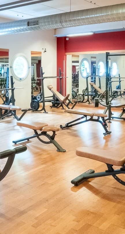 Sala pesi New Way Fitness con panche, bilancieri e specchi